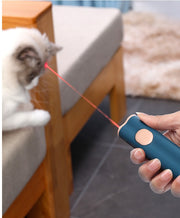 laser feather cat toy being used to entertain a cat, featuring a hand holding the laser pointer.